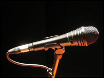 A microphone on a stand with black background