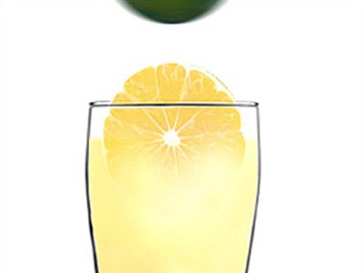 A glass of orange juice with an apple in the background.