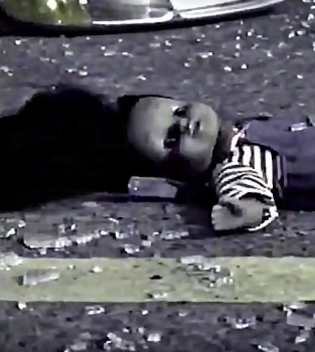 A doll laying on the ground in front of a street.